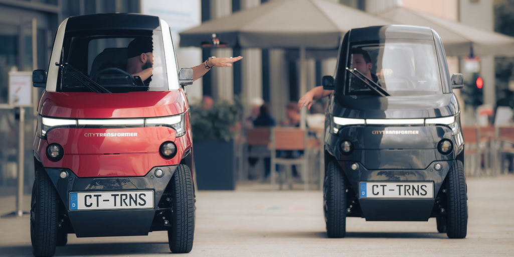 Dos coches plegables en la calle y dos hobres hablando