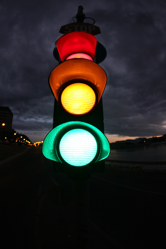 Fish eye photo from a traffic lamp. Photo was taken  at night. All lamps (red, yellow, green) are lighting.