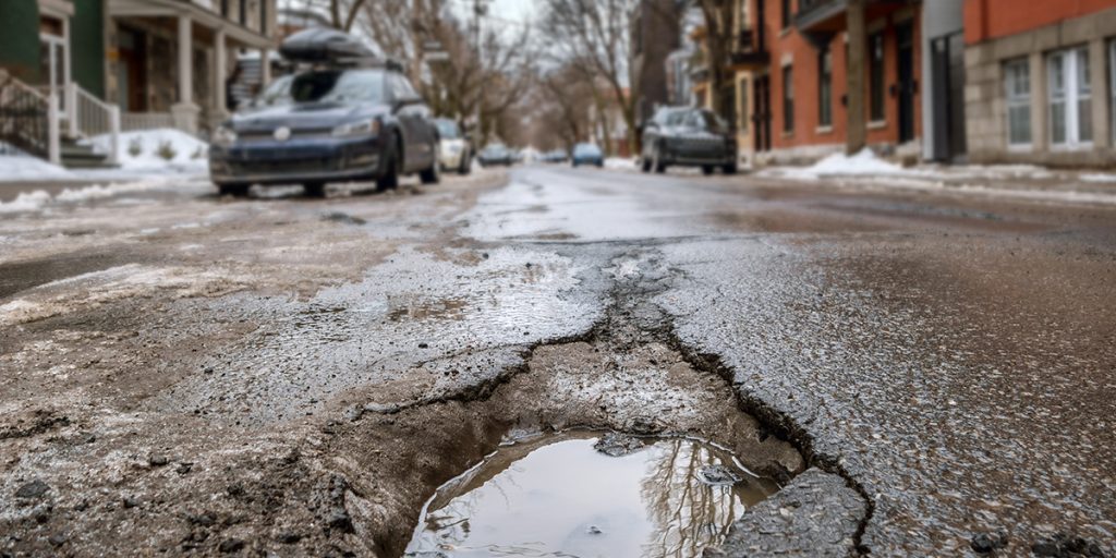 calle con baches y coches